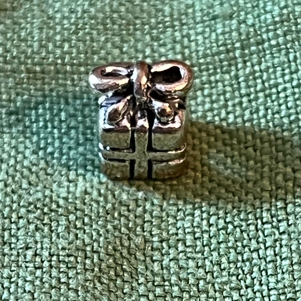 Pandora silver ribbon-wrapped gift charm. 1/4” around, 1/3” high, never worn